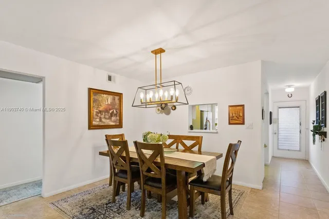 a view of a dining room with furniture and chandelier