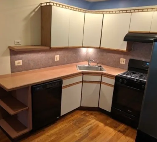 a kitchen with a sink a stove and cabinets