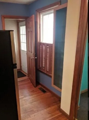 a view of a hallway with wooden floor and staircase
