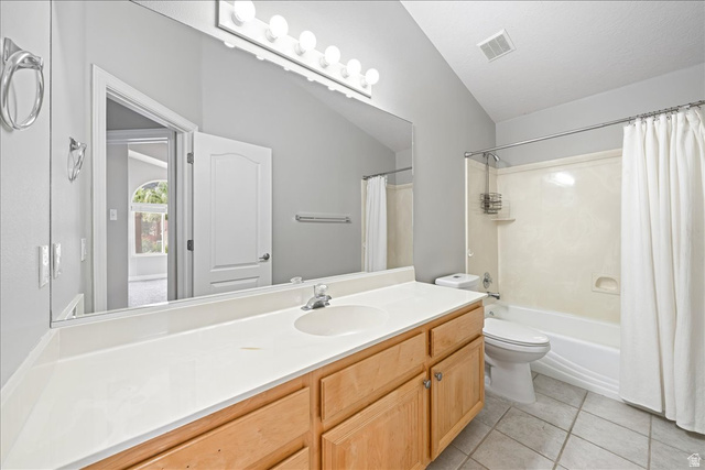 7 Reflection Way St. George, UT 84770 - Photo 33 of 54 Bathroom featuring vanity, shower / tub combo with curtain, lofted ceiling, and light tile patterned floors
