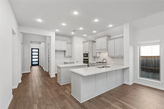 a kitchen with kitchen island a sink stainless steel appliances and cabinets