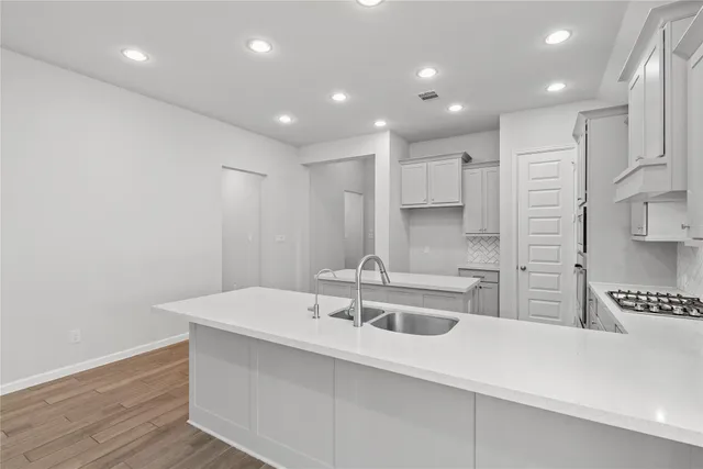 a kitchen with stainless steel appliances sink stove microwave and cabinets