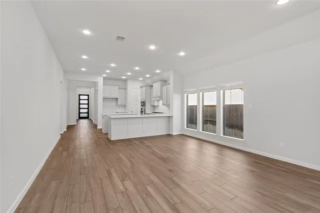 an empty room with wooden floor and fireplace