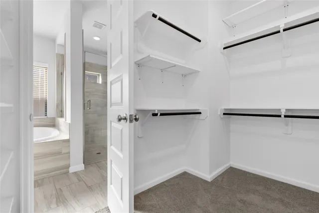a bathroom with a granite countertop bathtub shower sink vanity and toilet