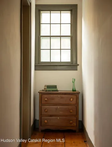 a bedroom with a bed a mirror and a window