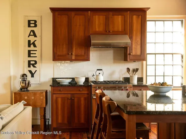 a kitchen with granite countertop a sink a stove and wooden cabinets