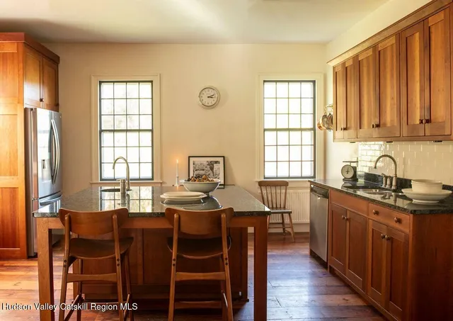 a dining room with stainless steel appliances granite countertop furniture a kitchen island a stove and a window