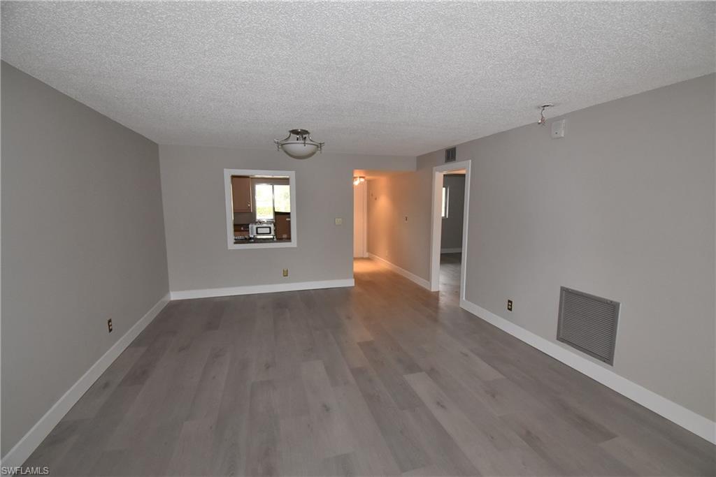 5667 Rattlesnake Hammock Road, Unit B205 Naples, FL 34113 - Photo 16 of 16 Spare room with wood finished floors and a textured ceiling