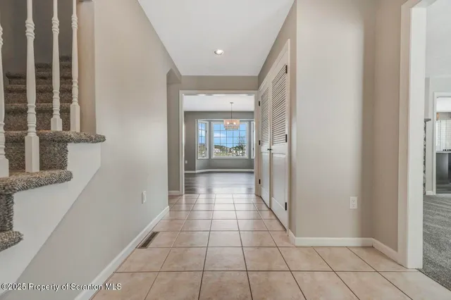 a kitchen with stainless steel appliances granite countertop a refrigerator a sink dishwasher a stove a dining table and chairs with wooden floor