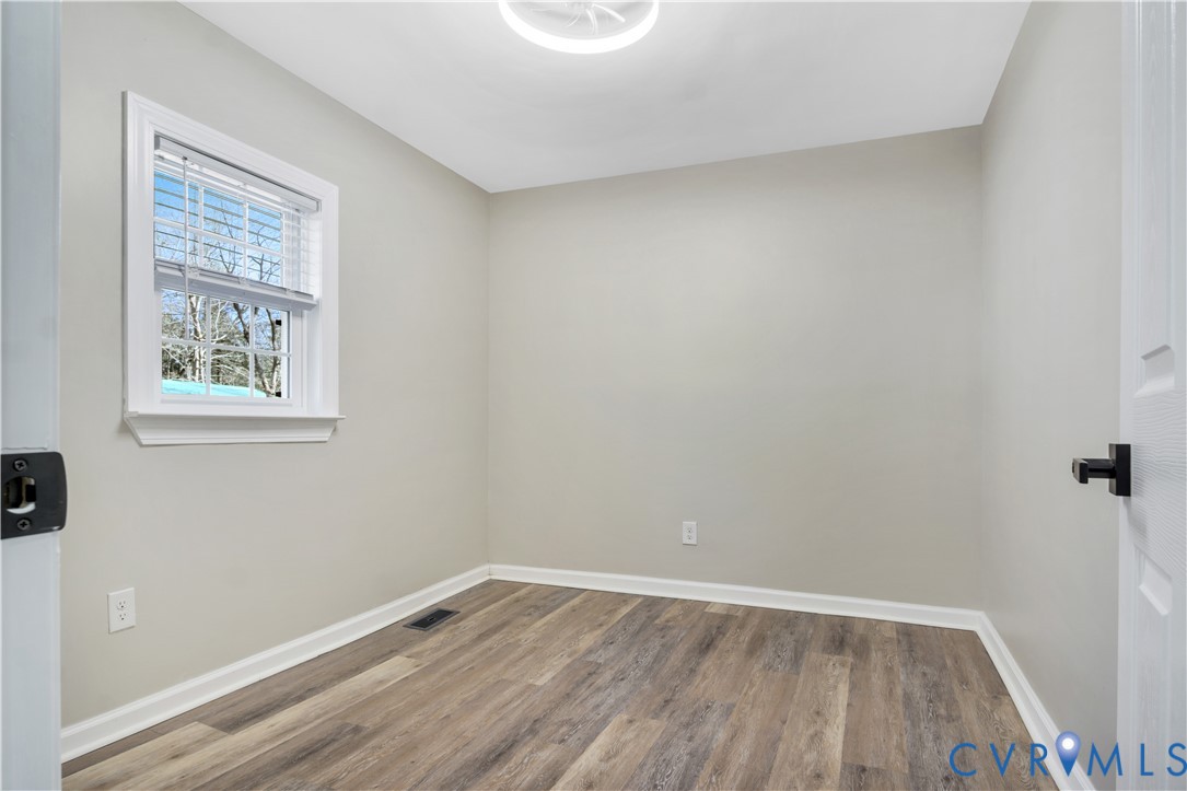 113 Red Dirt Road Williamsburg, VA 23188 - Photo 29 of 41 a view of an empty room with wooden floor and a window