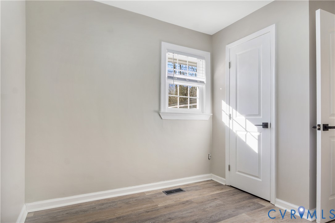113 Red Dirt Road Williamsburg, VA 23188 - Photo 31 of 41 an empty room with wooden floor and a window