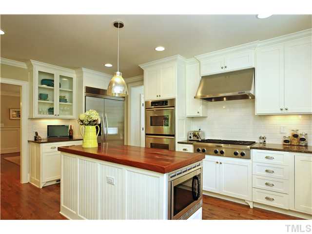 611 Runnymede Road Raleigh, NC 27607 - Photo 3 of 25 a kitchen that has a lot of cabinets in it and wooden floors