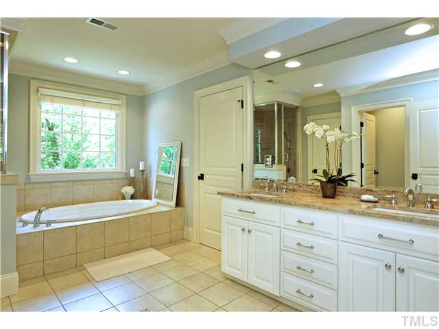 611 Runnymede Road Raleigh, NC 27607 - Photo 6 of 25 a spacious bathroom with a double vanity sink a mirror and a bathtub