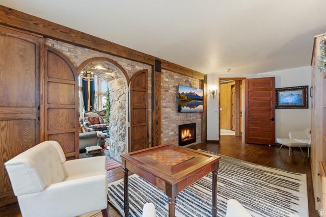 2687 Stewart Road Sundance, UT 84604 - Photo 16 of 48 Living room with wood-type flooring, a brick fireplace, and arched walkways