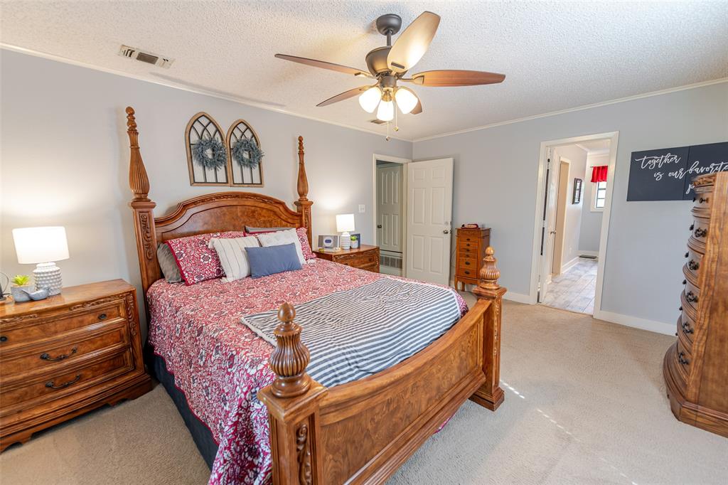 180 Se Creek Scroggins, TX 75480 - Photo 11 of 24 a bedroom with a bed and a chandelier