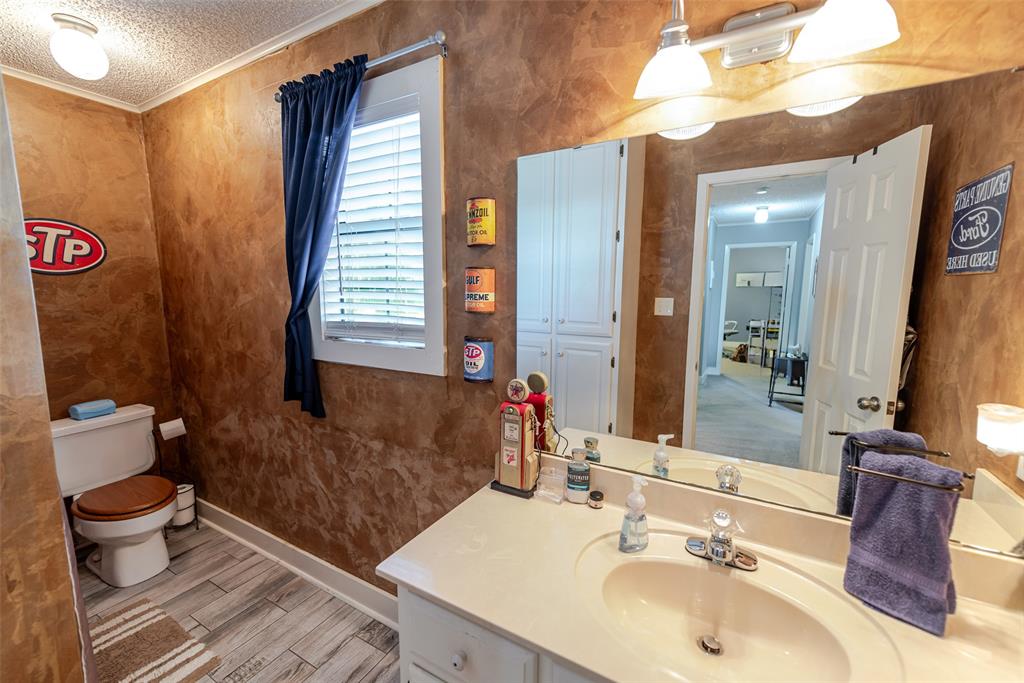 180 Se Creek Scroggins, TX 75480 - Photo 17 of 24 a bathroom with a sink and a mirror