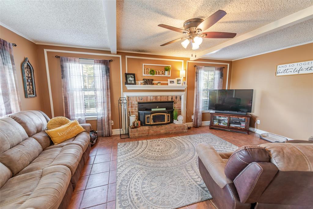180 Se Creek Scroggins, TX 75480 - Photo 4 of 24 a living room with furniture a flat screen tv and a fireplace
