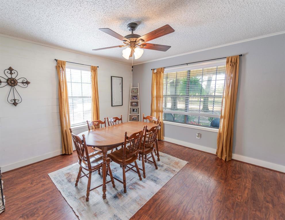 180 Se Creek Scroggins, TX 75480 - Photo 10 of 24 a dining room with wooden floor a chandelier a wooden table and chairs