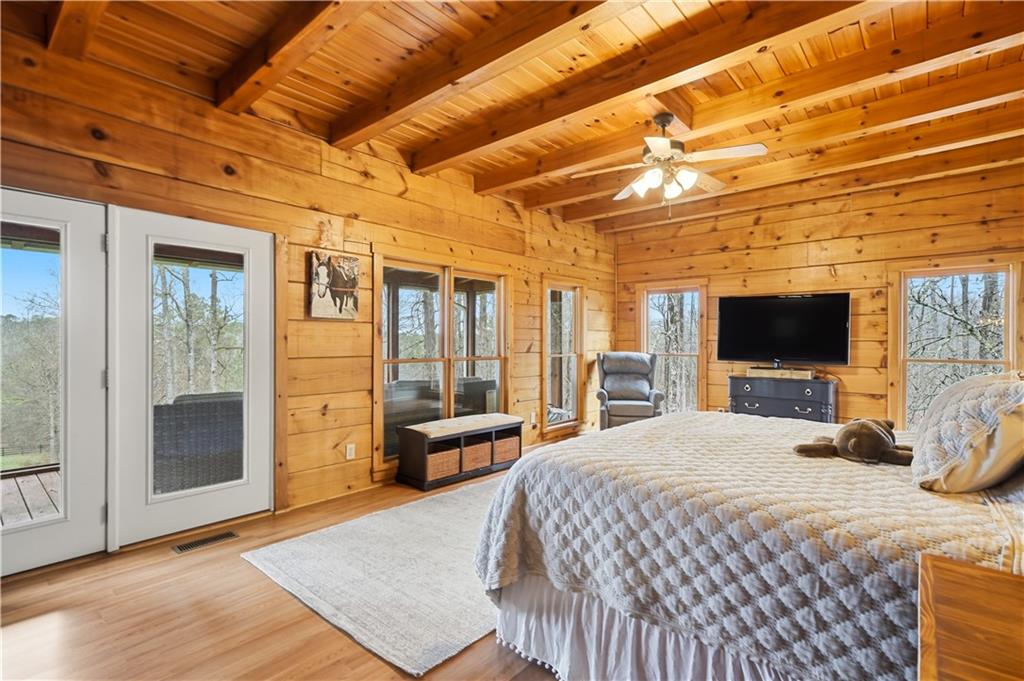 2865 Hightower Road Ball Ground, GA 30107 - Photo 18 of 41 a bedroom with a bed a flat screen tv and balcony view