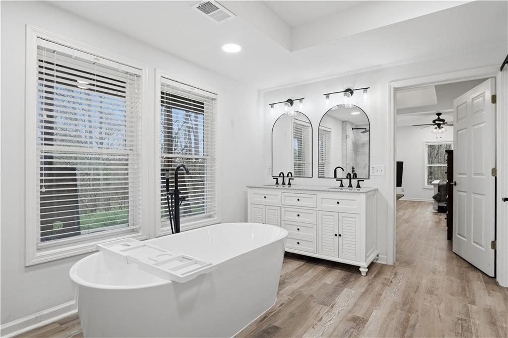 2865 Hightower Road Ball Ground, GA 30107 - Photo 32 of 41 a bathroom with a granite countertop sink mirror bathtub and window