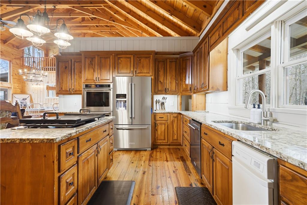 2865 Hightower Road Ball Ground, GA 30107 - Photo 8 of 41 a kitchen with stainless steel appliances granite countertop a sink a stove a refrigerator cabinets and a dining table
