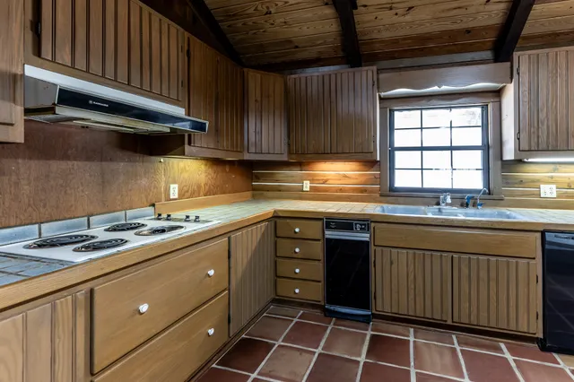 a kitchen with stainless steel appliances granite countertop a sink counter space cabinets and a large window