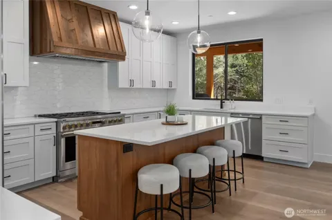 a kitchen with stainless steel appliances granite countertop a sink a stove and a refrigerator