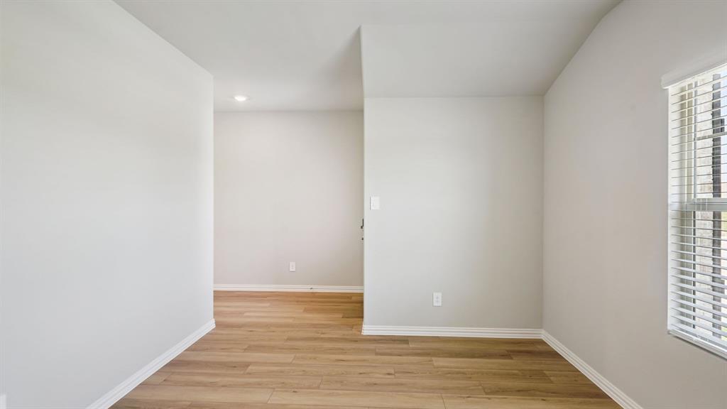 2218 Rannoch Street Sherman, TX 75092 - Photo 15 of 28 a view of an empty room with wooden floor and a window