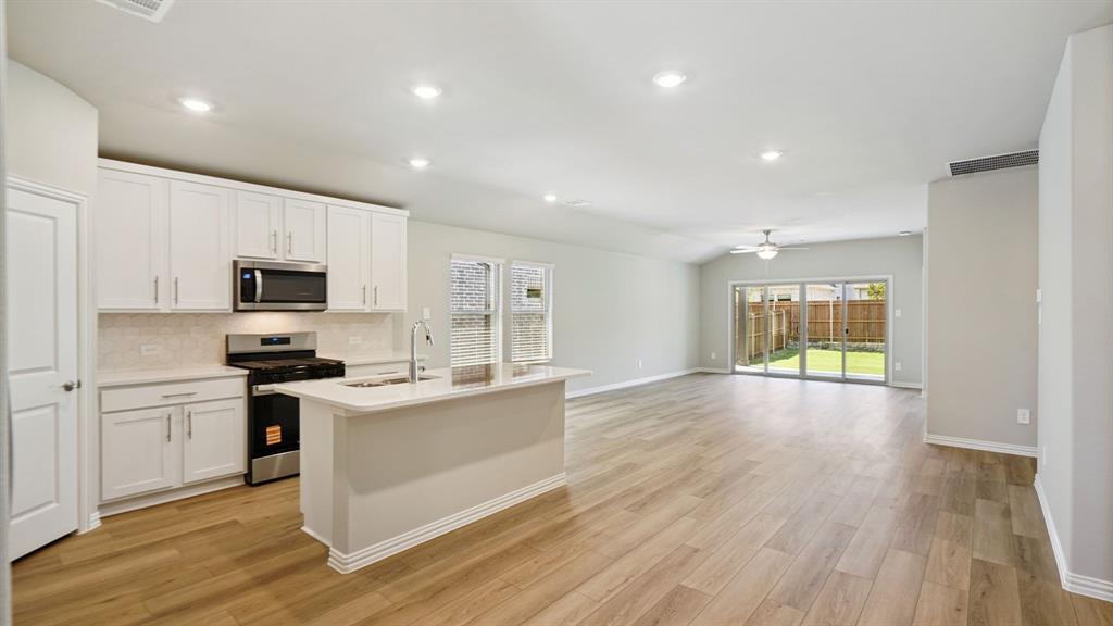 2218 Rannoch Street Sherman, TX 75092 - Photo 3 of 28 a kitchen with stainless steel appliances granite countertop a stove a sink and a refrigerator