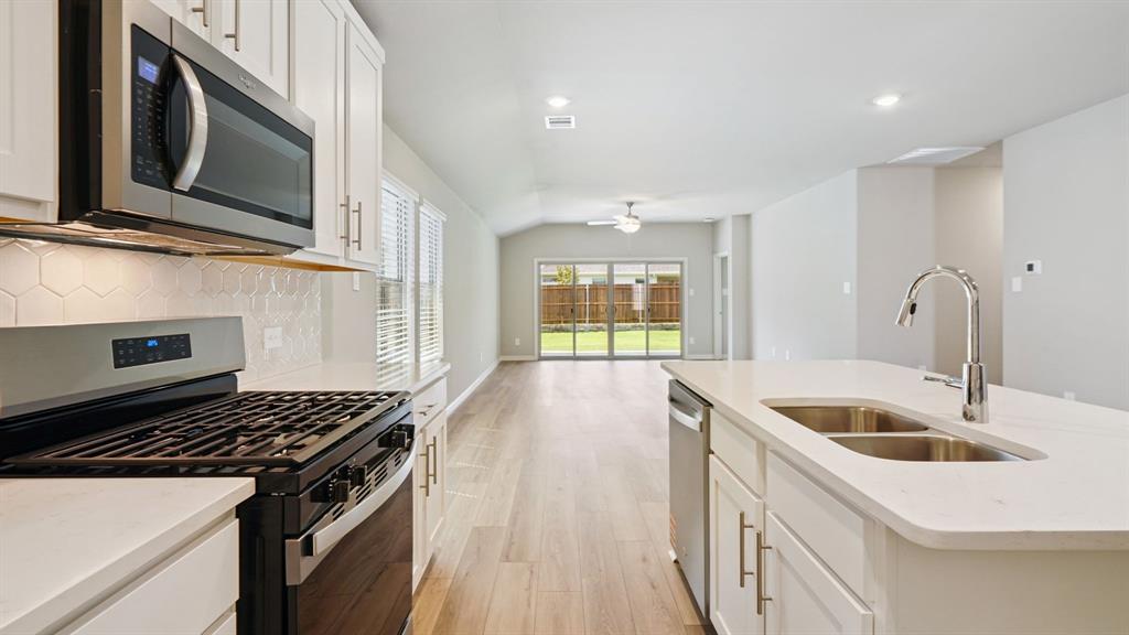 2218 Rannoch Street Sherman, TX 75092 - Photo 5 of 28 a kitchen with stainless steel appliances granite countertop a sink and a stove
