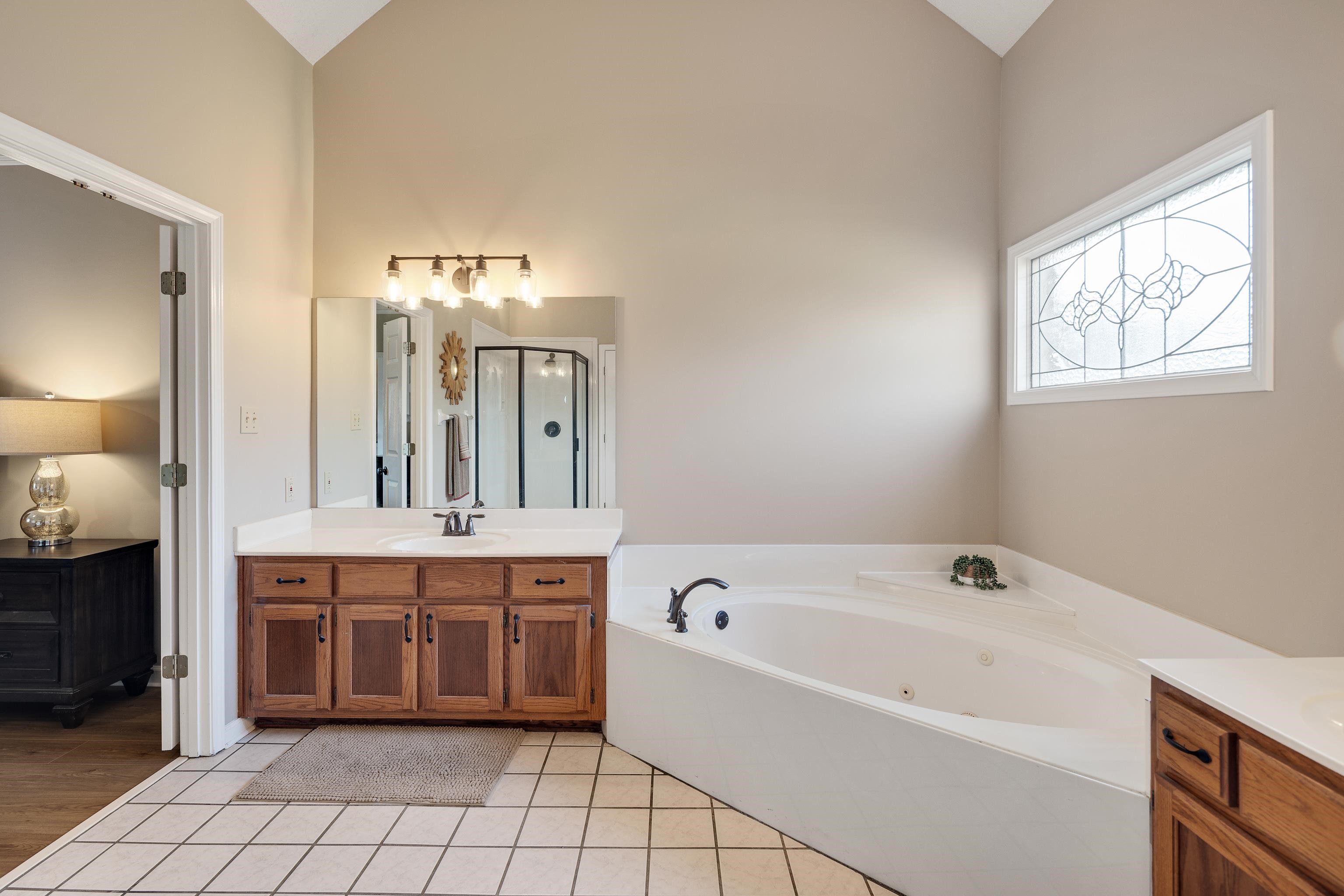 540 Whitney Way Collierville, TN 38017 - Photo 16 of 22 Bathroom with vanity, a tub with jets, light tile patterned flooring, a stall shower, and lofted ceiling