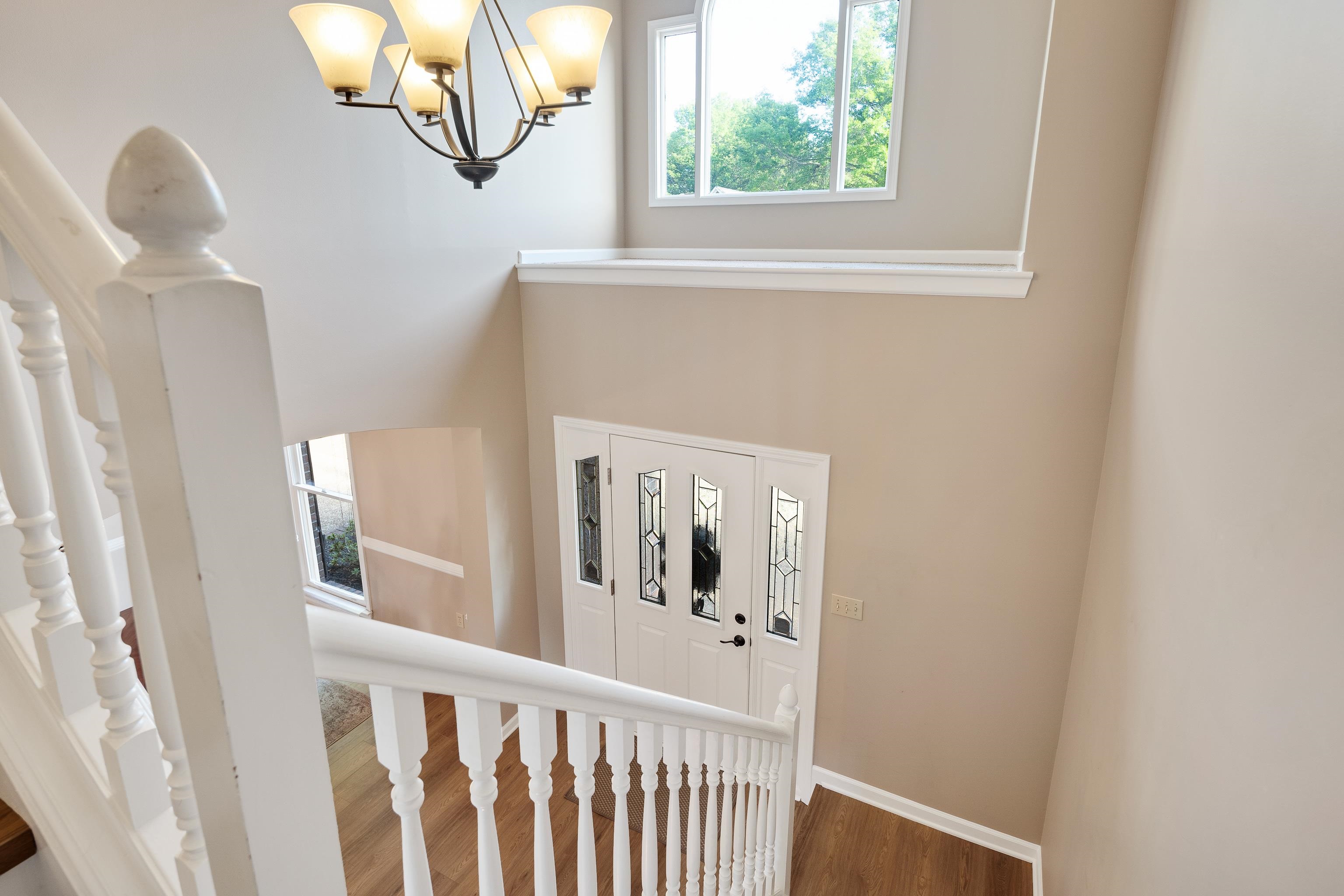 540 Whitney Way Collierville, TN 38017 - Photo 18 of 22 Staircase with plenty of natural light, a chandelier, and wood finished floors