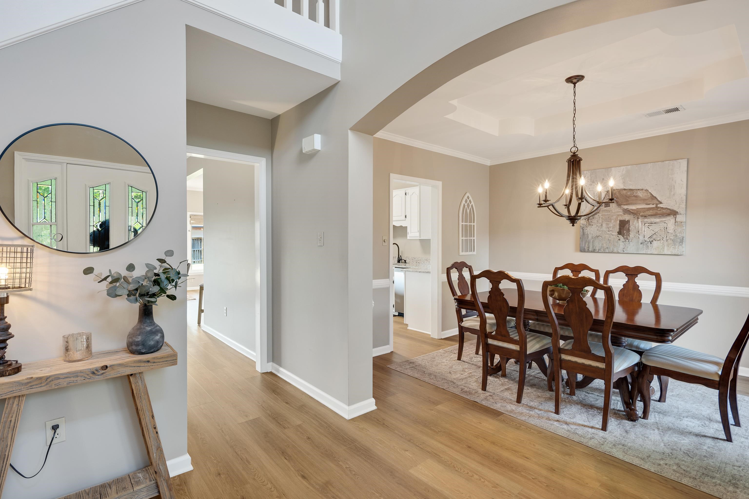 540 Whitney Way Collierville, TN 38017 - Photo 3 of 22 Dining room with a raised ceiling, ornamental molding, suspended lighting, light wood-style flooring, and arched walkways