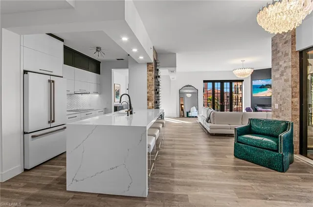 a living room with furniture and a refrigerator