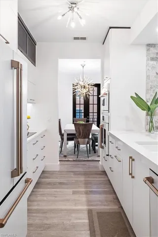 a living room with furniture and a large mirror with wooden floor