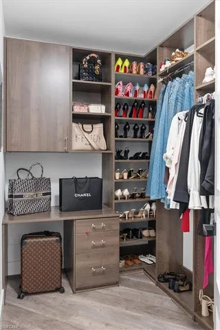 a view of walk in closet with clothes and shoes