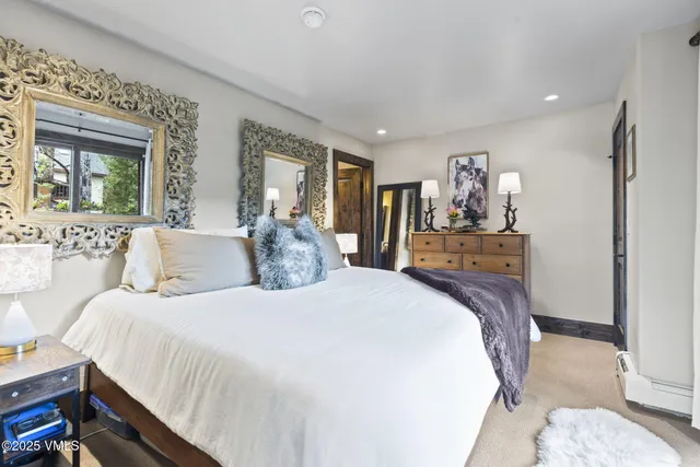 a spacious bedroom with a bed and glass door