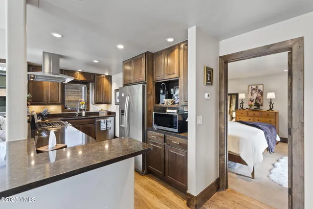 a kitchen with stainless steel appliances granite countertop a refrigerator a stove and a sink