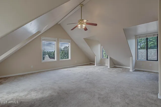a view of an empty room with a chandelier fan