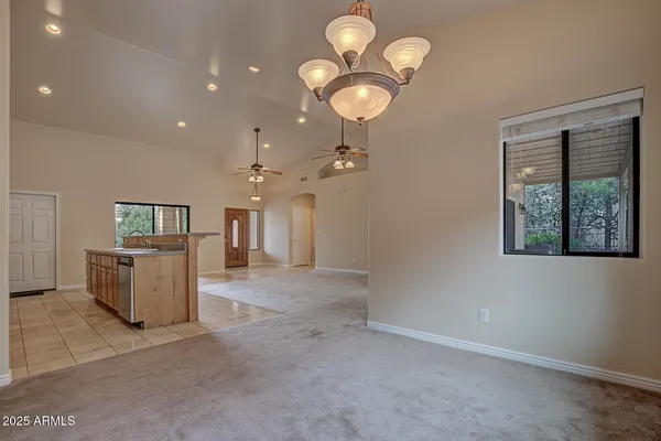an empty room with windows and ceiling fan