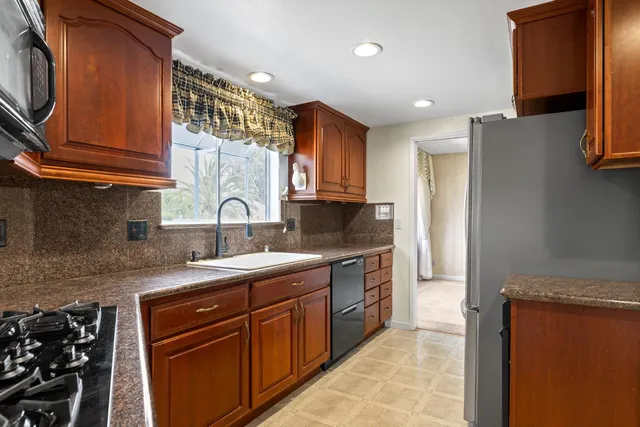 a kitchen with stainless steel appliances granite countertop a sink stove and refrigerator