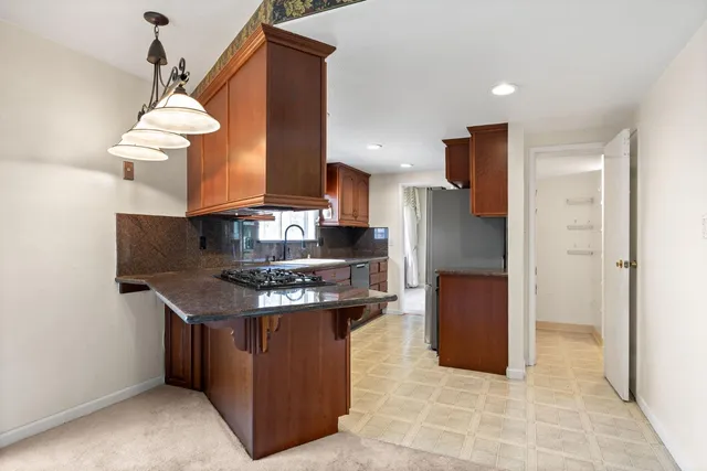 a kitchen with stainless steel appliances granite countertop a stove and a refrigerator