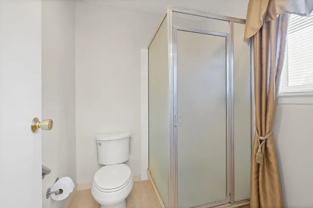 a bathroom with a granite countertop toilet a sink and a mirror