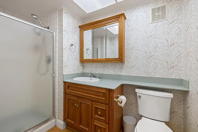 a bathroom with a toilet sink vanity and mirror
