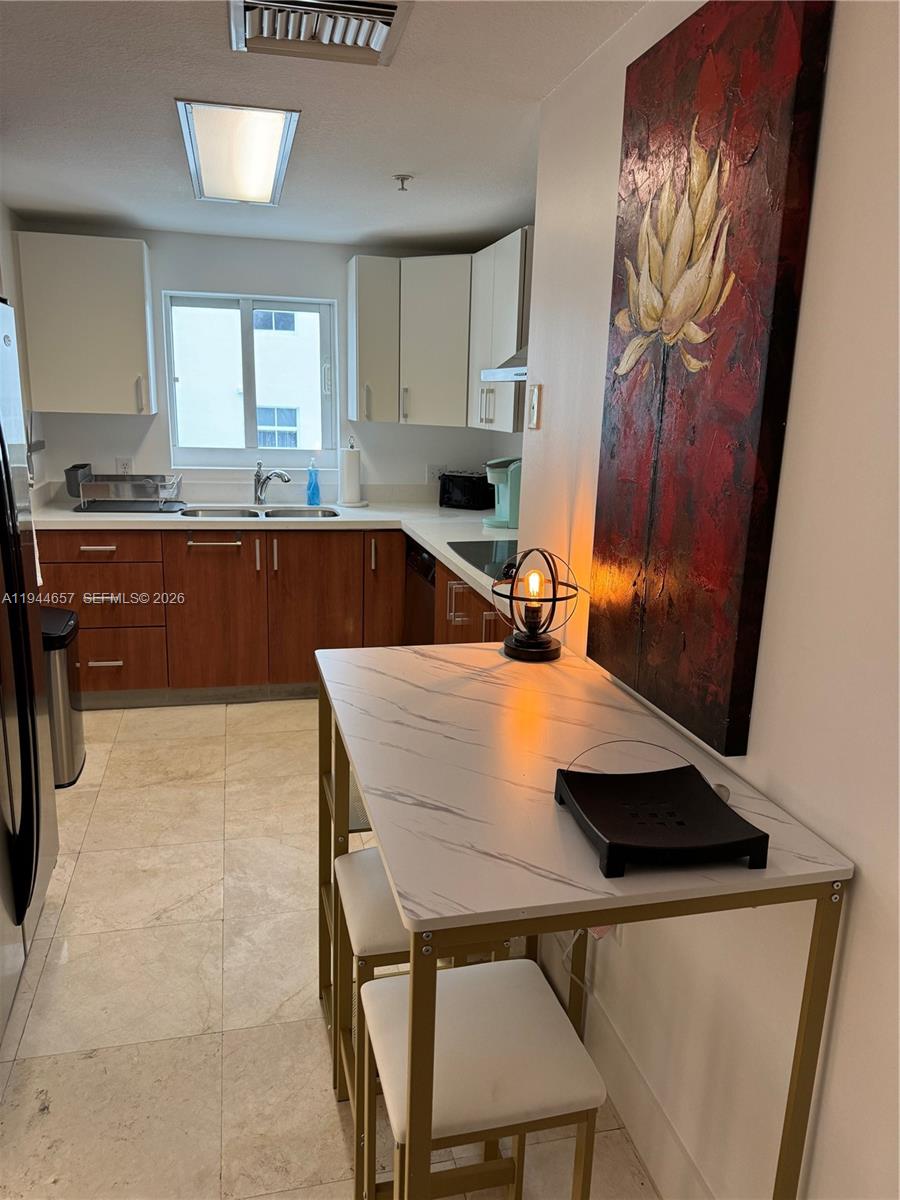 170 Southeast 14th Street, Unit 2405 Miami, FL 33131 - Photo 11 of 25 a kitchen with a sink a stove and cabinets