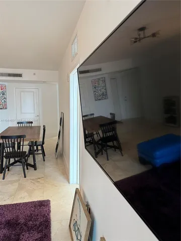 a kitchen with stainless steel appliances granite countertop a stove top oven a dining table and chairs with wooden floor