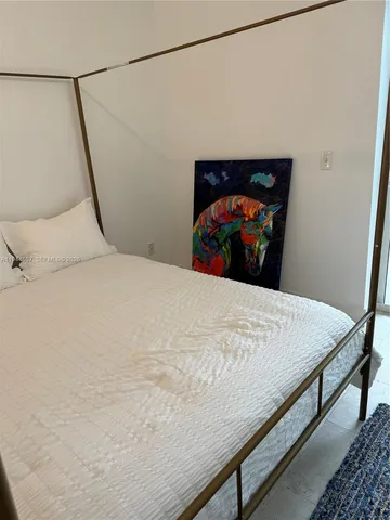 a bed sitting in a bedroom and a mirror