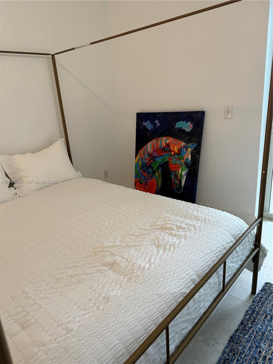 170 Southeast 14th Street, Unit 2405 Miami, FL 33131 - Photo 17 of 25 a bed sitting in a bedroom and a mirror