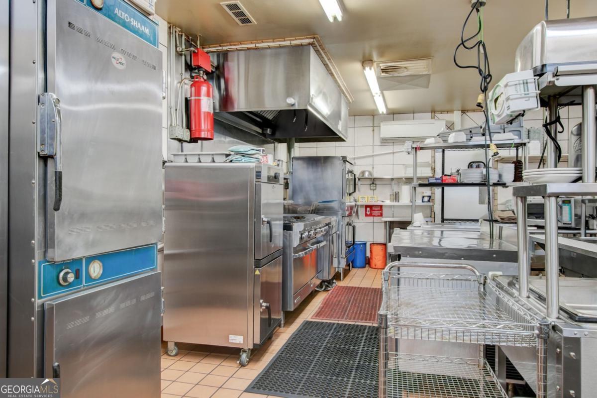 868 County Line Road Resaca, GA 30735 - Photo 29 of 44 a kitchen with stainless steel appliances kitchen island granite countertop a refrigerator and a stove