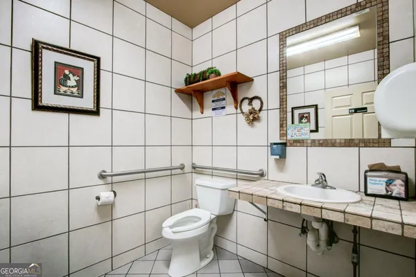 a bathroom with a toilet a sink and a mirror